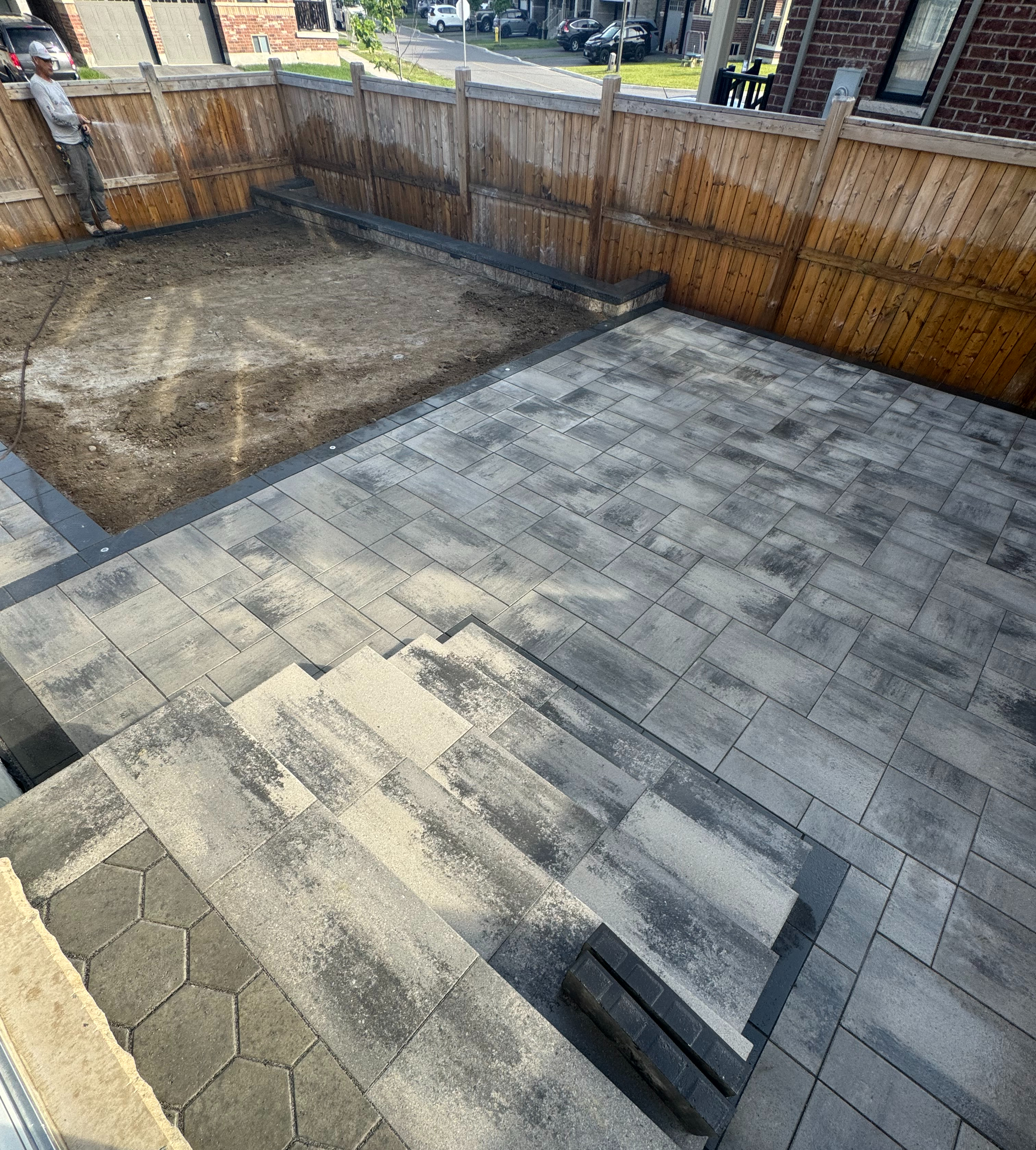 Backyard interlock in progress — multi-level layout with steps and hexagonal accents