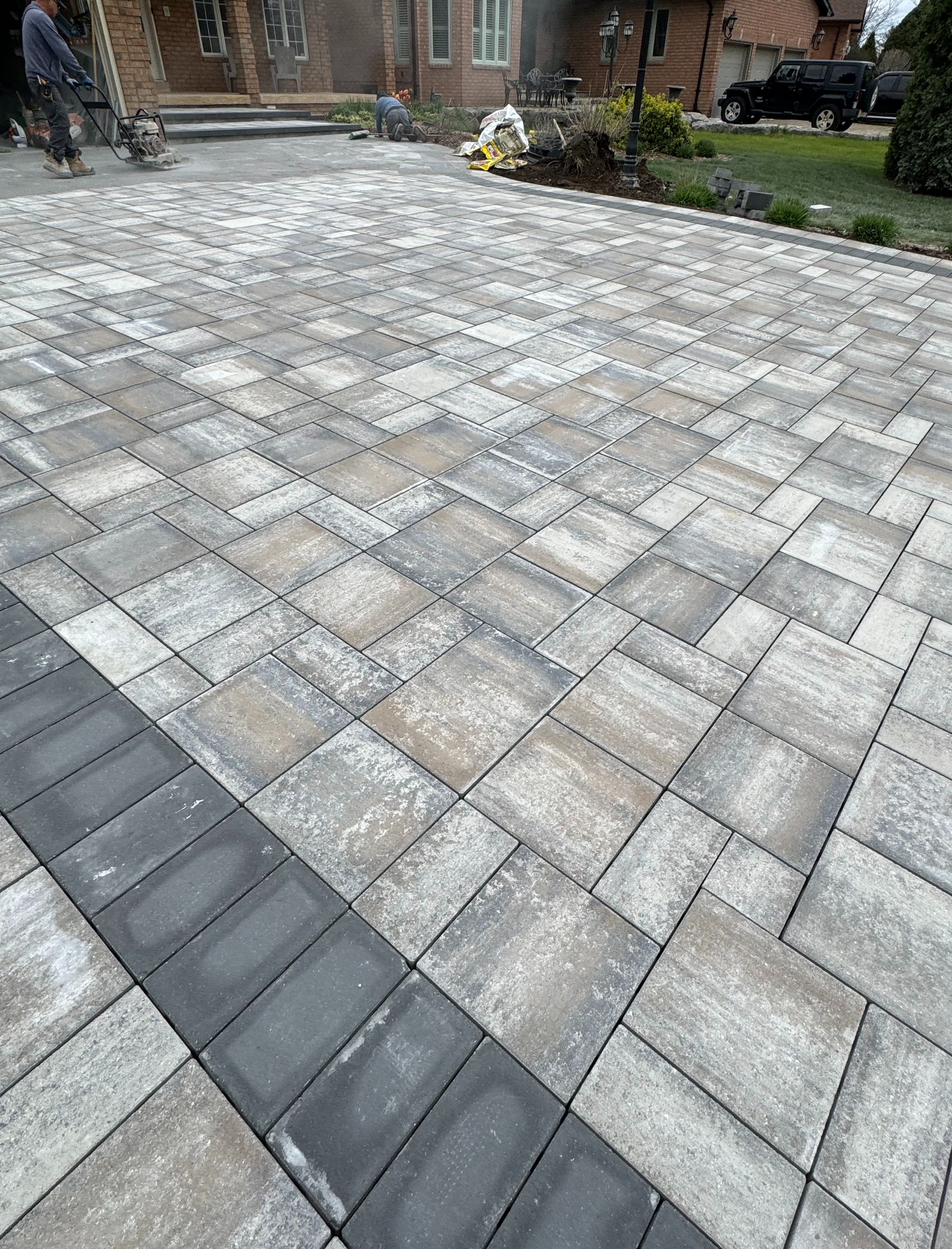 Interlock driveway installation in progress — multi-tone herringbone pattern GTA