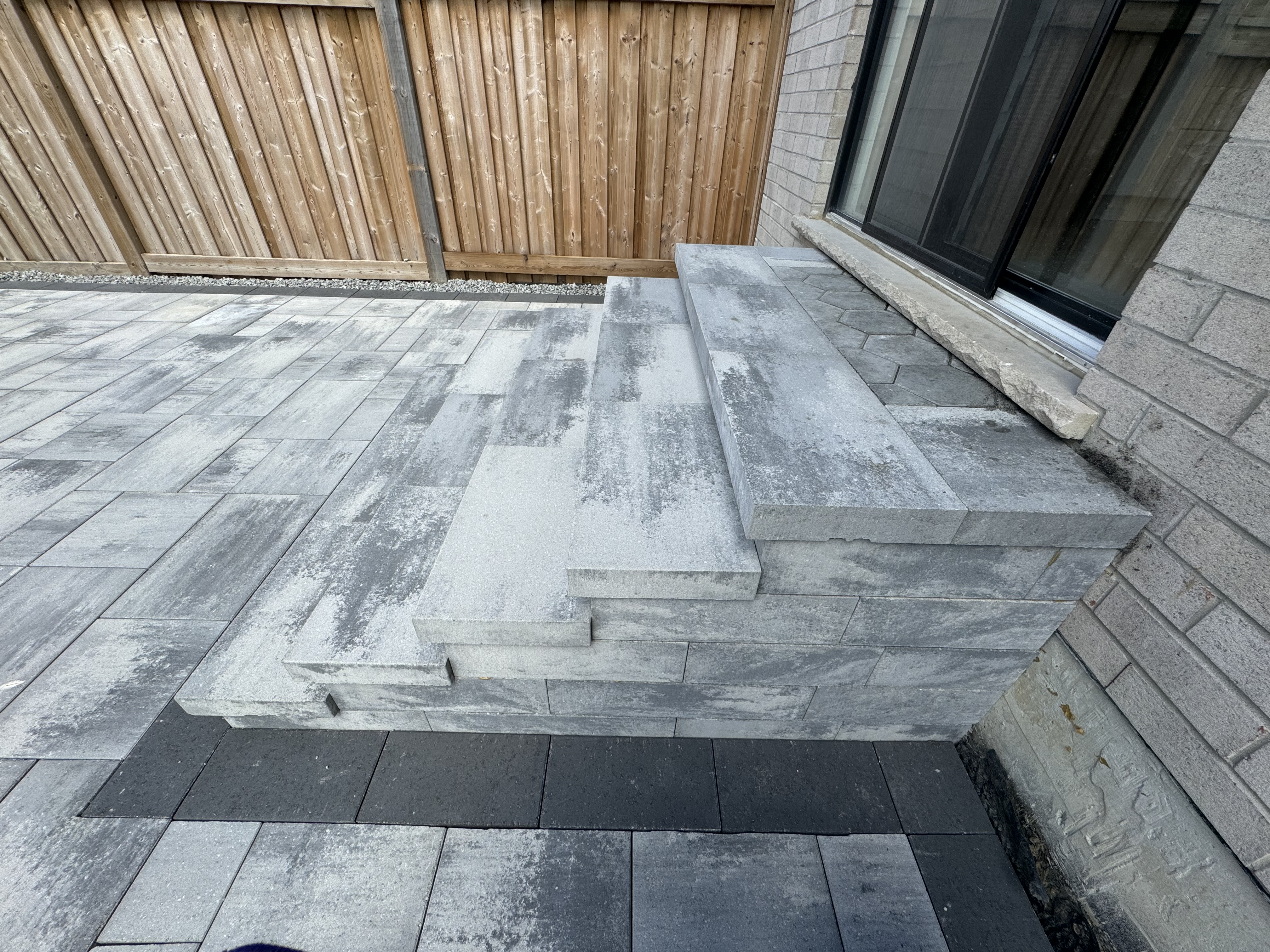 Custom large-format slab steps with chiseled edge detail against brick home