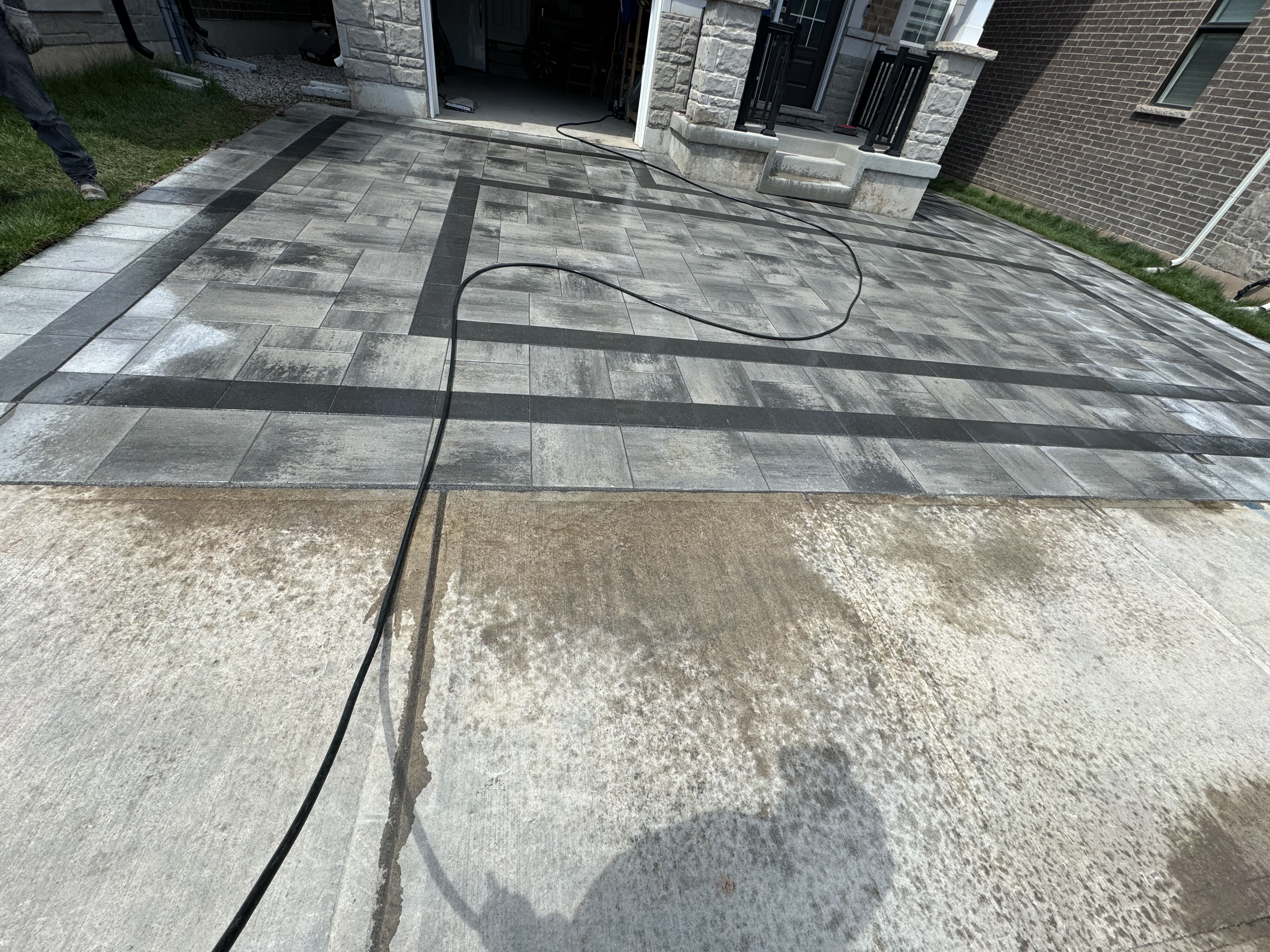 Interlock driveway half-complete showing contrast against old concrete