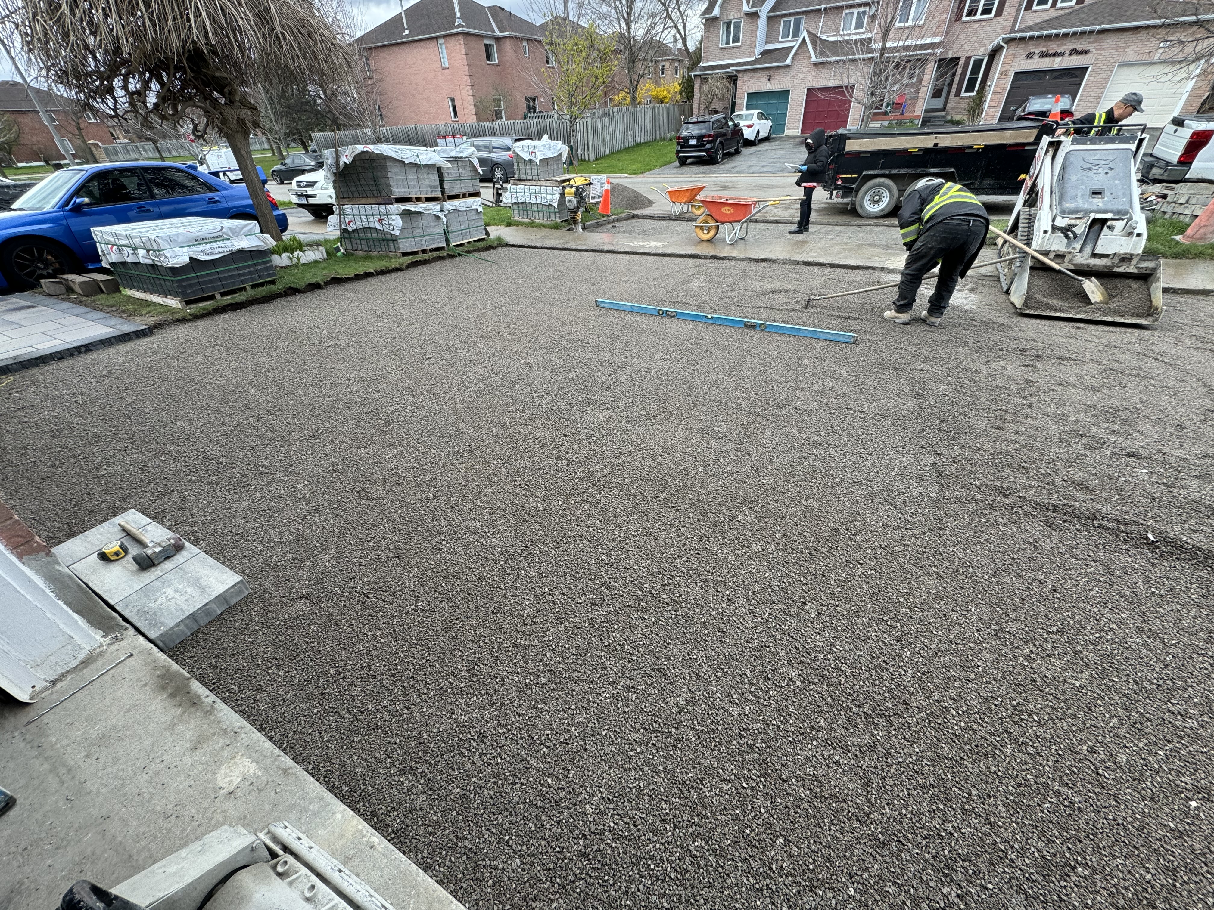 Crew leveling granular A base for interlock driveway installation
